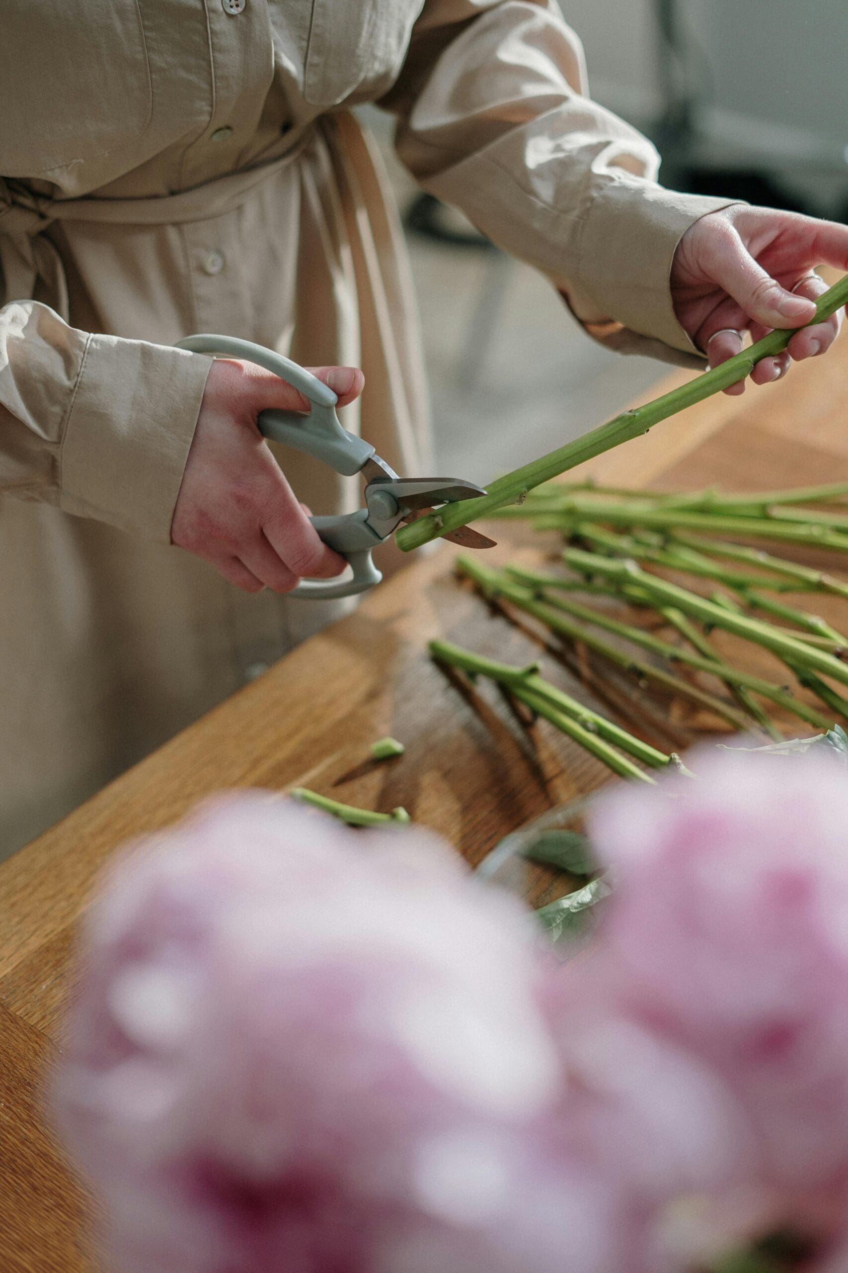 Florist trimming pink flowers for a wedding's bridal bouquet